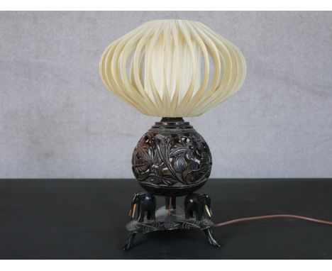 An early 20th century carved coconut design table lamp with silk finned shade on tripod elephant supports. H.36 W.26 D.25cm 