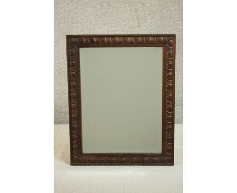 An early 20th century rectangular oak wall mirror, the frame carved with an egg and dart type design. H.50 W.39cm. 