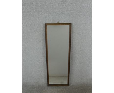 An early 20th century oak framed wall mirror of elongated form. H.96 W.34cm 