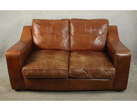 A late 20th century brown leather two seater sofa by Raft, with angular arms, on bun feet. H.86 W.166 D.31cm. 