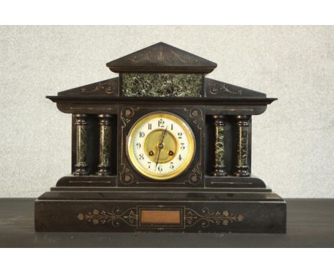 A Victorian slate marble mantel clock of architectural form with green marble pillars, French movement, the enamelled chapter