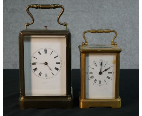 Two early 20th century gilt brass carriage clocks. The larger one with white enamel dial with black Roman numerals and faded 