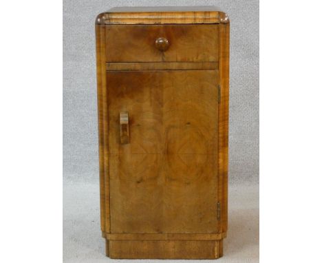 An Art Deco figured walnut pot cupboard with frieze drawer above panel door on plinth base. H.69 W.36 D.38cm 