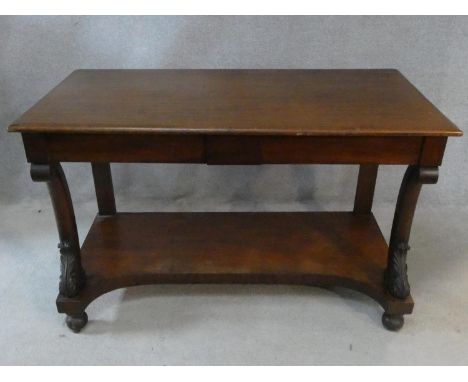 An early 19th century mahogany console table with frieze drawers and shaped and carved front supports on platform base restin