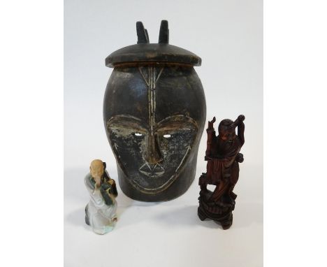 A carved wooden African tribal mask along with a carved wooden Chinese immortal and a ceramic figure of a Japanese old man. H