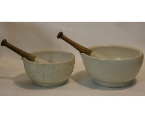 A large 19th century apothecary's ceramic mortar and pestle and another similar, stamped Made in England and numbered. Pestle