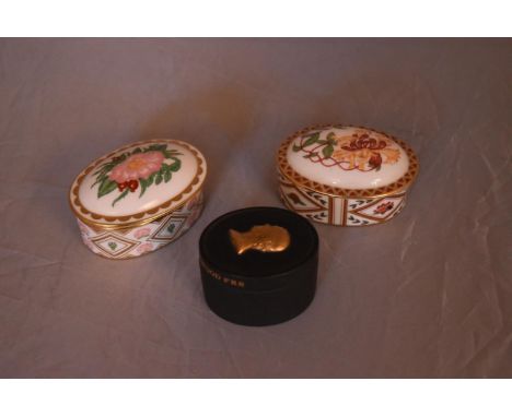 Three bone china and ceramic trinket boxes. Two by Royal Crown Derby, Wild Rose and Honeysuckle design. The other a black Wed