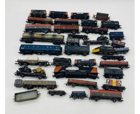 A collection of unboxed model railway OO gauge rolling stock including oil tankers, coal wagons, tank transporter, Railfreigh
