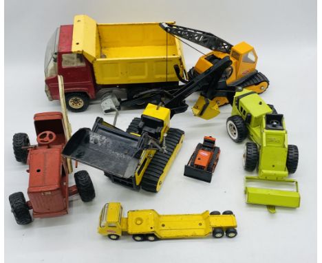 A collection of vintage Tonka toy vehicles including a dumper truck, crane, bulldozer, trencher loader, low loader etc, along