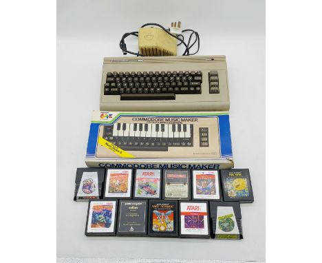 A vintage unboxed Commodore 64 computer with power supply, along with a boxed Commodore Music Maker and a selection of Atari 