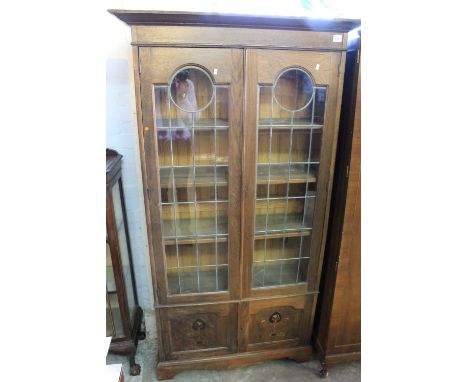 Art nouveau oak lead glazed book case cabinet with inlaid floral motifs.   CONDITION REPORT: One panel of glass bottom LHS mi