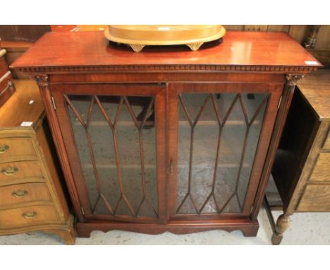 Reproduction mahogany glazed bookcase, raised on bracket feet. 