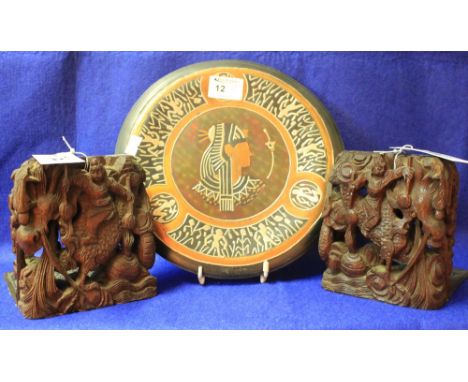 Pair of Chinese carved and pierced wooden book ends decorated with figures and scaly Dragons and having engraved brass bases.