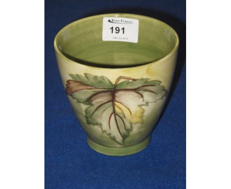 Moorcroft art pottery tapering cylinder vas, tube lined and painted with a  study of a leaf on graduated ground.  Impressed m