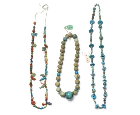  Two Egyptian faience bead necklaces and a necklace of Egyptian faience amulets, glass and carnelian  beads New Kingdom-Roman