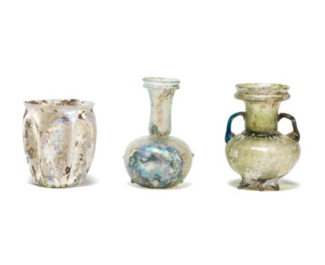  A Roman green glass sprinkler flask, a Roman pale blue-green glass flask, and a Roman colourless glass beaker Circa 1st-4th 