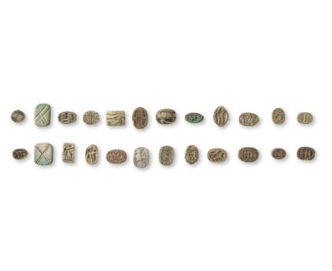 A group of twenty-four Egyptian steatite and faience scarabs, cowroids, plaques and beads Middle Kingdom-New Kingdom, circa 