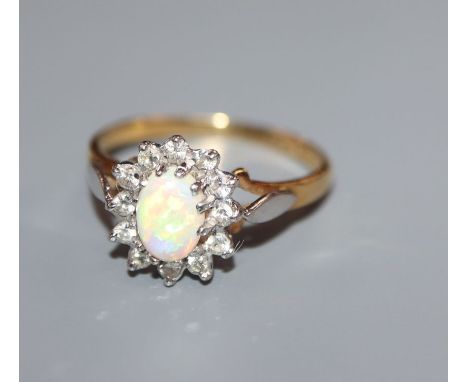 A modern 18ct gold white opal and diamond oval cluster ring, size O.