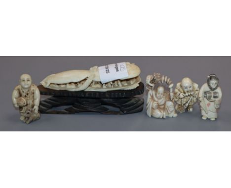 A Japanese ivory carving of a clam shell and four carved ivory netsuke