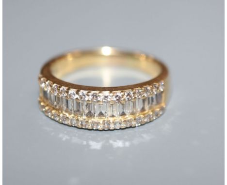 A modern 18k yellow metal and channel set baguette cut diamond set half hoop ring, with brilliant set borders, size M.