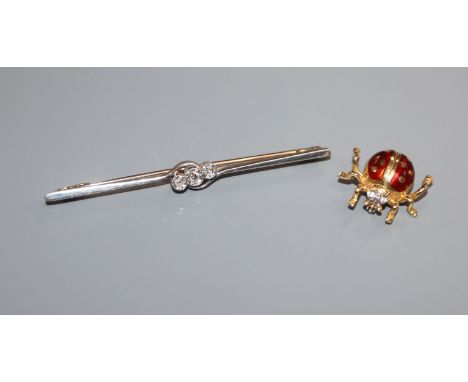 A 1920's 15ct, plat and three stone diamond bar brooch and an Italian 18k and enamel ladybird brooch.