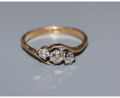 An 18ct and plat, three stone diamond crossover ring, size M.