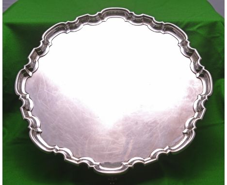 A substantial silver tray on four scrolled feet with decorative raised edge. Hallmarked for Sheffield 1936, for the Atkin Bro