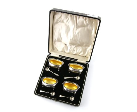 Cased set of four silver and yellow enamel bowl salts with lion mask paw feet with silver salt spoons, by Alexander Clark and