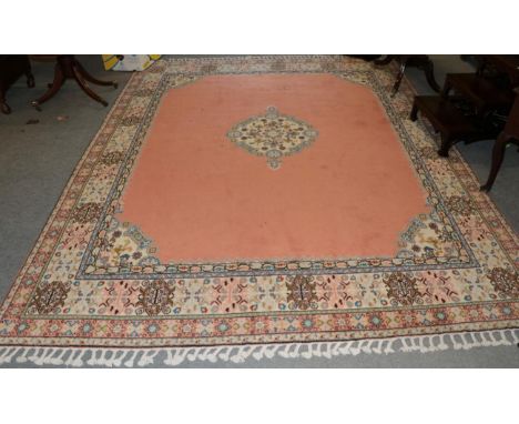 A Moroccan carpet, the salmon pink field with central medallion framed by spandrels and ivory borders, 315cm by 250cm