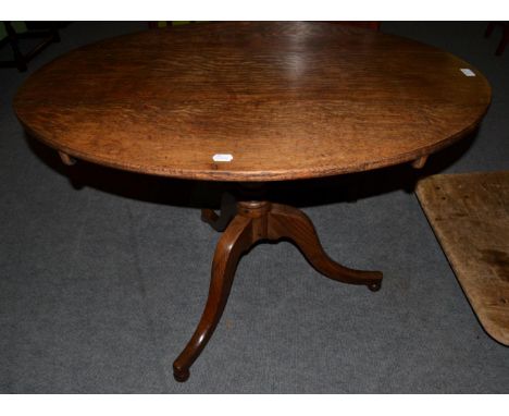 A George III oval topped oak tilt top tripod table