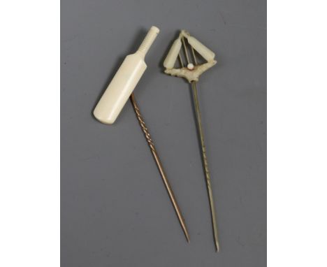 Two ivory mounted cricket related stick pins, one modelled as a cricket bat, the other as cricket bats, ball and stumps, long