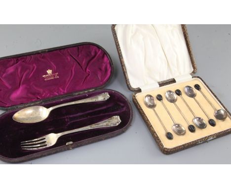 A cased set of six George V silver bean end coffee spoons and a cased christening spoon and fork (knife missing).