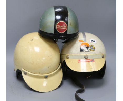 Three vintage racing helmets