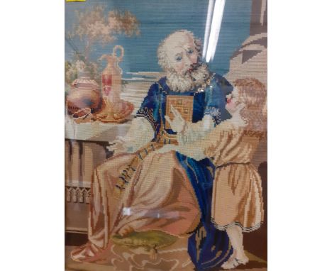 A 20th century tapestry in woollen cross-stitch depicting a religious man teaching a child, framed in an ornate gilt frameLoc