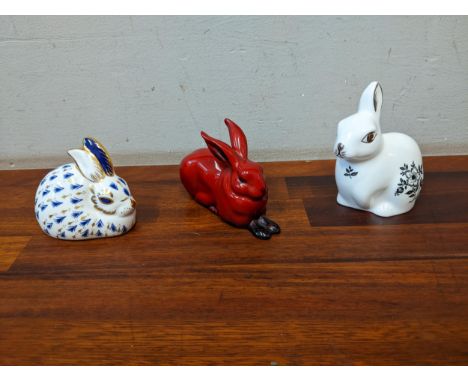 Three model rabbits, comprising two Royal Crown Derby paperweights and a Royal Doulton flambe glazed exampleLocation: 