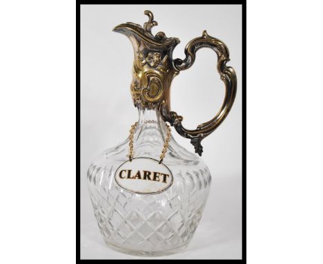 A early 20th Century silver plated claret jug, having cut crystal glass bulbous body and tapering neck, having mounted ornate