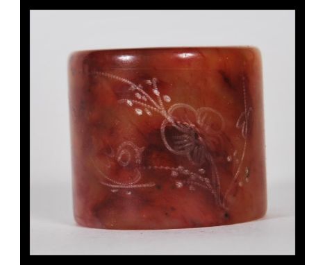 A early 20th Century Chinese large mottled dark red jade archer's thumb ring of cylindrical form.