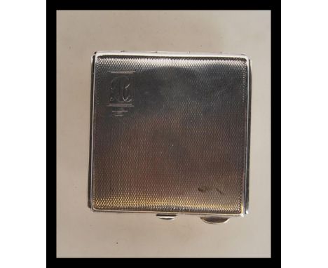 An early 20th Century silver hallmarked ladies compact of square form having engine turned decoration, complete with mirror t