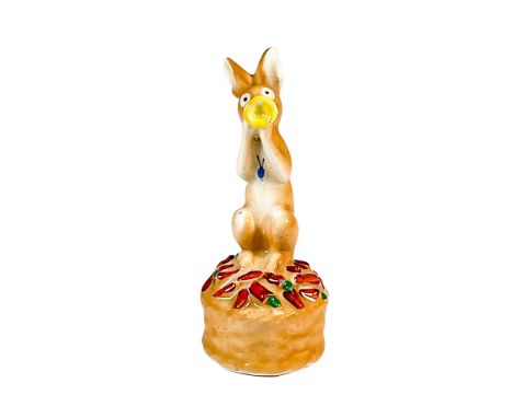 Early figure of a rabbit playing a trumpet surrounded by carrots. Hand painted in brown, yellow, and orange coloration. Royal