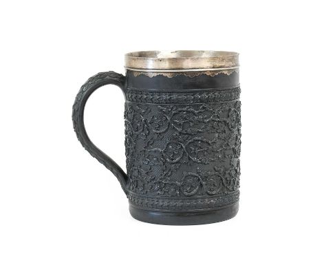 A White Metal Mounted Wedgwood Black Basalt Large Mug, circa 1800, decorated in relief with scrolling foliage on an engine-tu