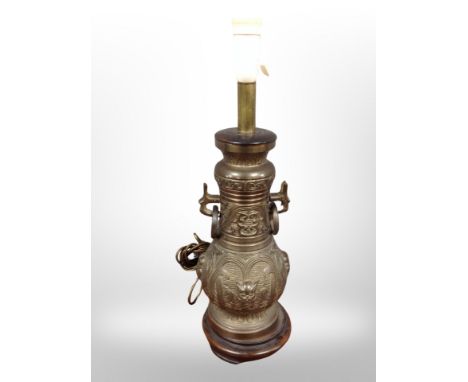 A heavy cast brass oriental style lamp base on wooden stand, height 50 cm  CONDITION REPORT: Continental plug.