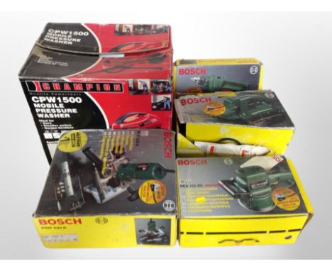 A group of boxed power tools, Bosch drill, sander, Champion pressure washer 