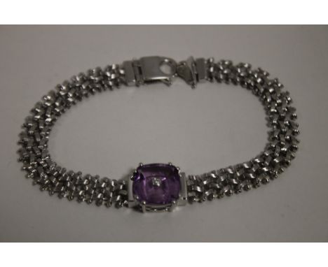 A AMETHYST AND DIAMOND SILVER BRACELET,  having a cushion cut amethyst of approx 4.3 carats, measuring 12 mm by 12 mm with ap