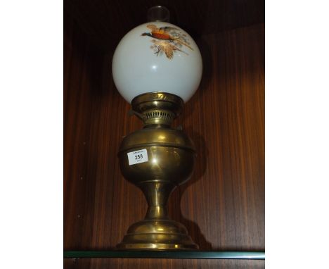 A VINTAGE OIL LAMP WITH GAME BIRD DECORATED SHADE