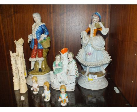 A PAIR OF LARGE CONTINENTAL STYLE FIGURES, TOGETHER WITH A STAFFORDSHIRE STYLE FLAT BACK POSY HOLDER, THREE PIN CUSHION DOLLS