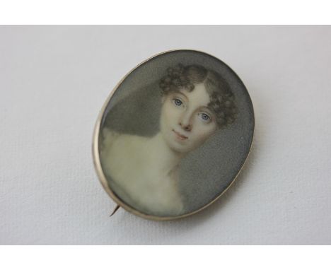 English School, circa 1820 a portrait miniature of a young lady with centre-parted curled hair in gold brooch mount