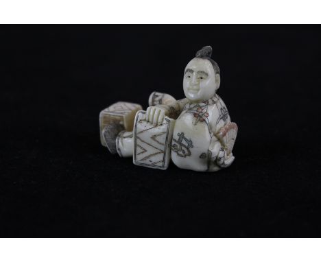 A 19th century Japanese ivory netsuke of a seated man, character mark to base