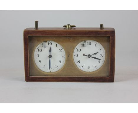A mahogany cased chess clock with two circular white enamel dials and Arabic numerals, 14cm by 8cm