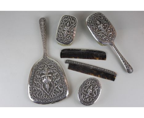 A Thai sterling silver backed dressing table set comprising hand mirror, hair brush, clothes brush, a comb and a pot, togethe