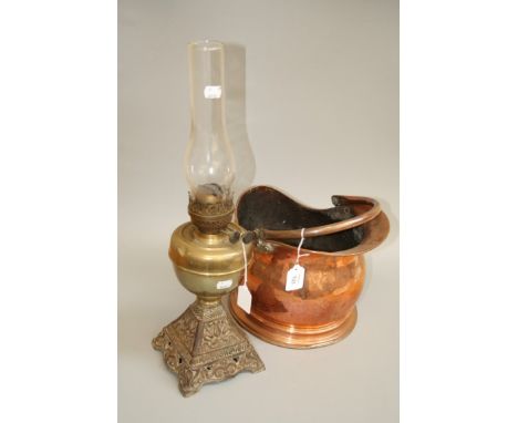 A Victorian copper helmet coal scuttle, and an Edwardian paraffin lamp with brass reservoir and spreading iron base
